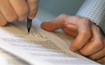 Man's Hands Signing Document --- Image by © Royalty-Free/Corbis